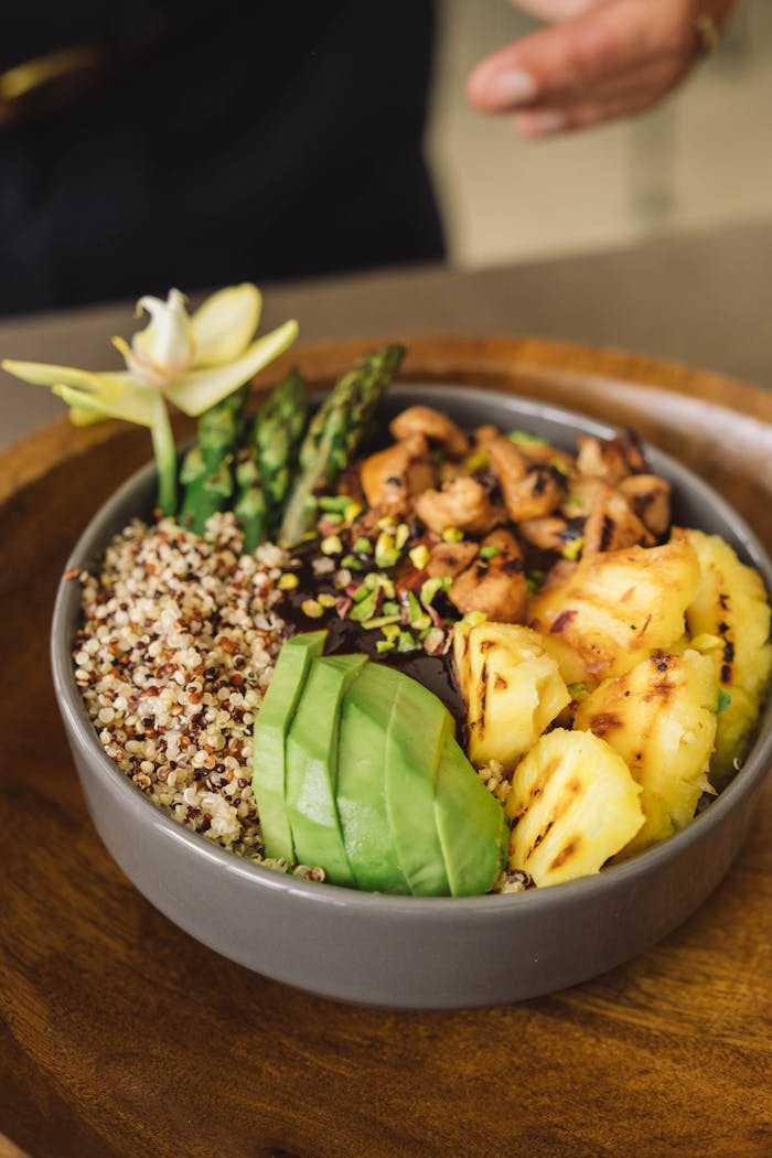 Healthy and colorful Buddha bowl with quinoa, avocado, asparagus, and pineapple.